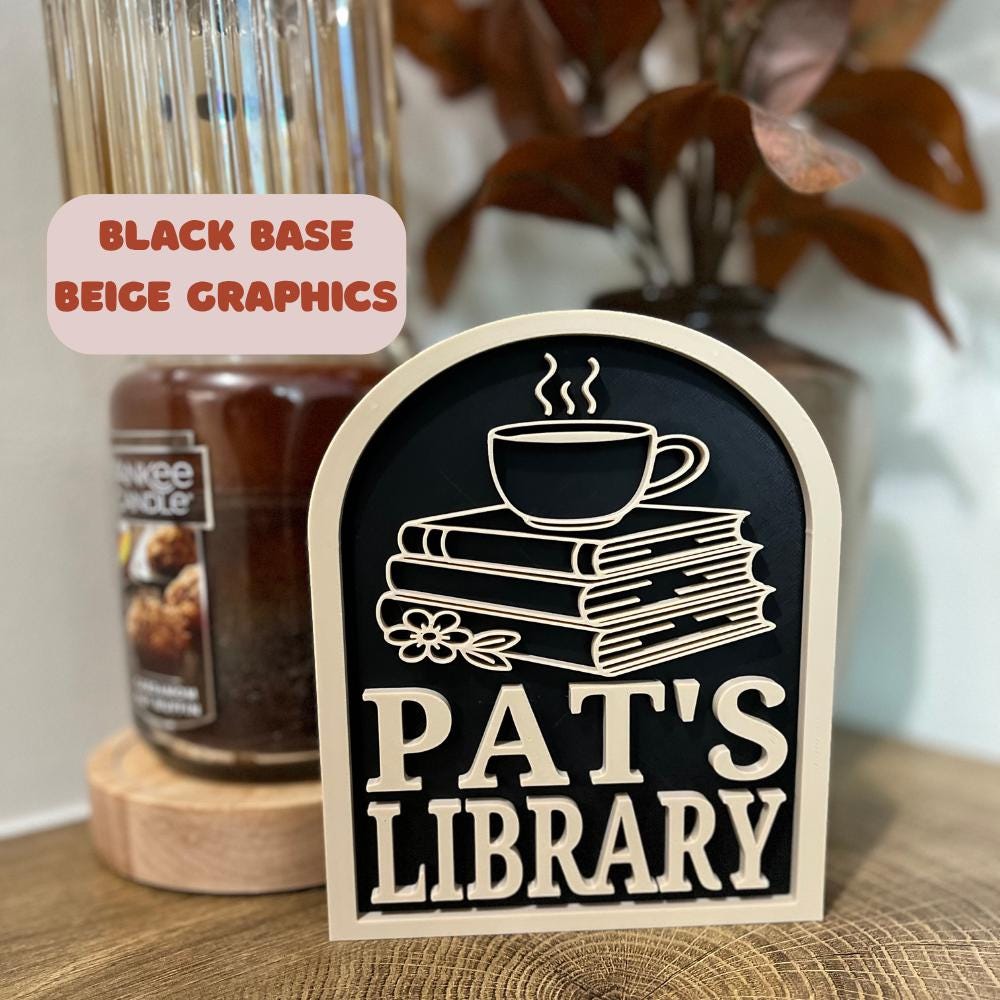 Personalized library sign with beige text and graphics on black base, books and coffee cup design