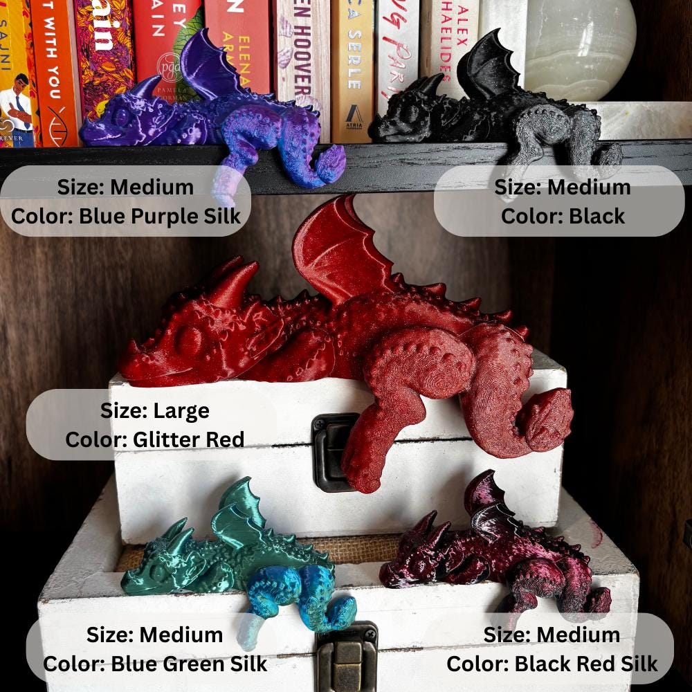 Vibrant colored sleeping dragons in multiple colors and sizes perched on a bookshelf, using eco-friendly PLA, bright fantasy Four Wing inspired accent. Colors include blue purple silk, glitter black, sparkle black, glitter red, sparkle red, blue green silk, and black red silk. Sizes include small, medium, large, and extra large