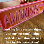 Custom pink and red AMANDA'S LIB street sign with text about ordering a custom sign