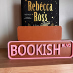 Back of the small brown sign behind the large BOOKISH BLVD street sign