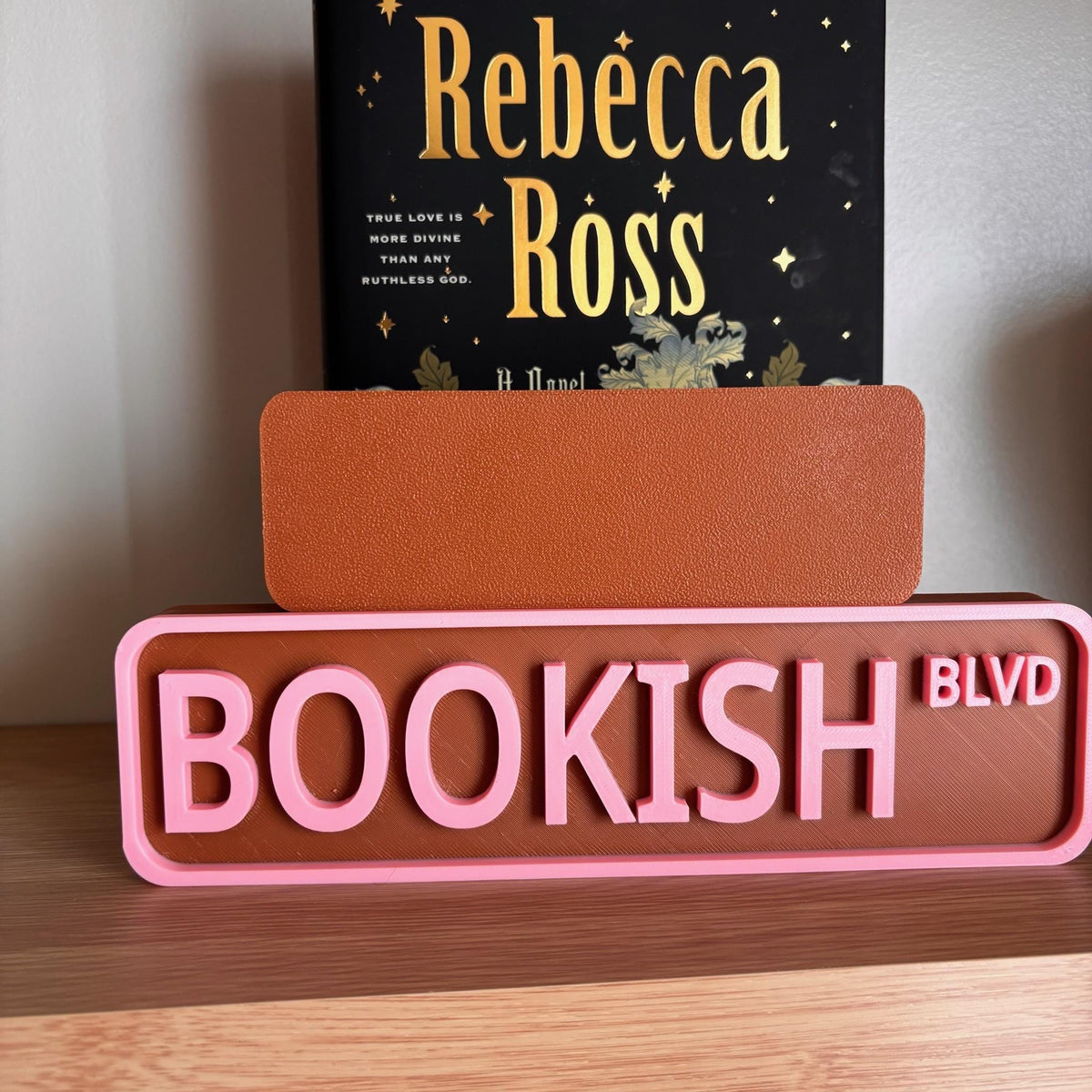Back of the small brown sign behind the large BOOKISH BLVD street sign