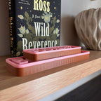 Side profile of the brown and pink BOOKISH BLVD street signs lying flat