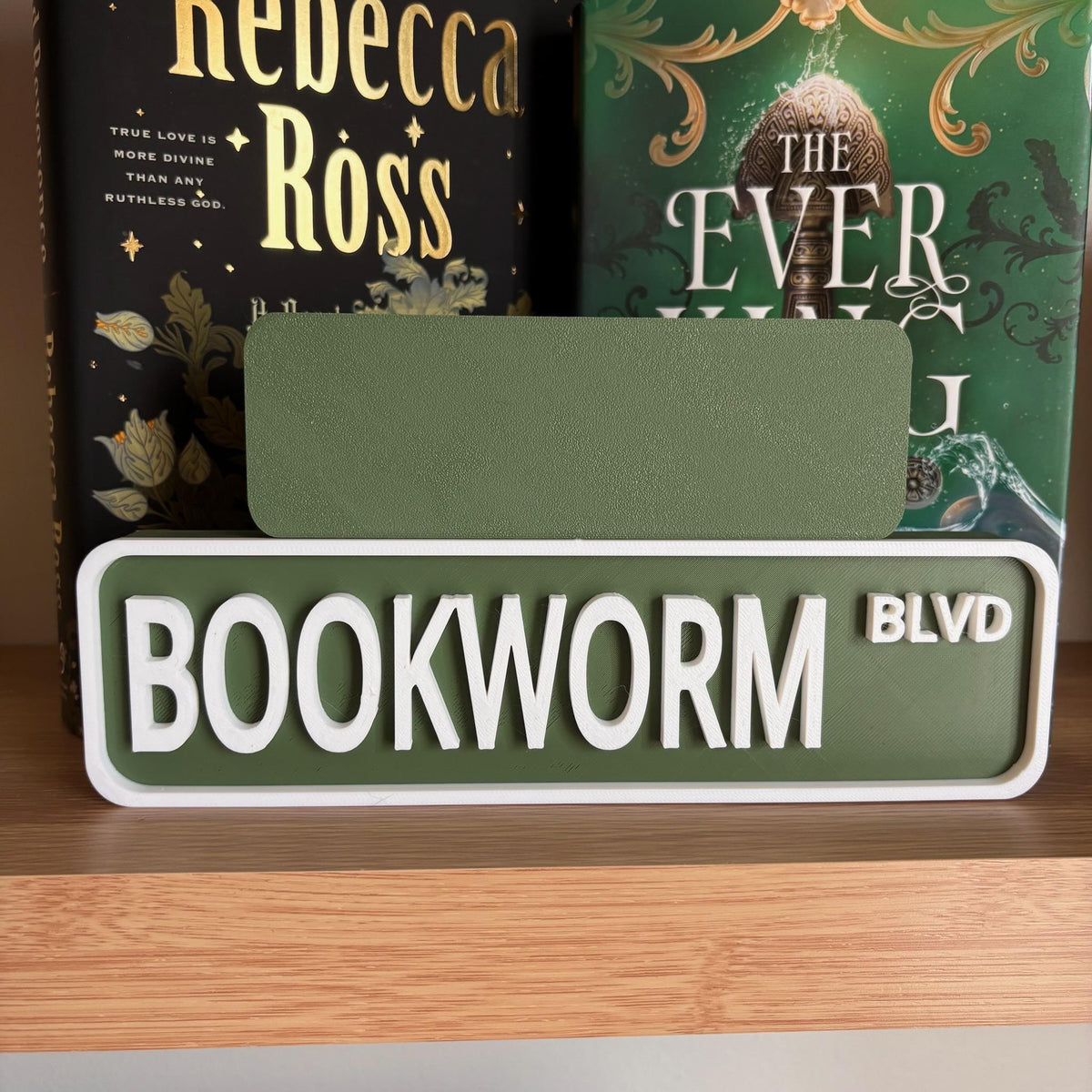 Back of the small green sign behind the large BOOKWORM BLVD street sign