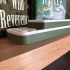 Side profile of the olive green and white BOOKWORM BLVD street signs lying flat