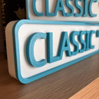 Close angled view of the raised teal lettering on the CLASSIC CT street sign