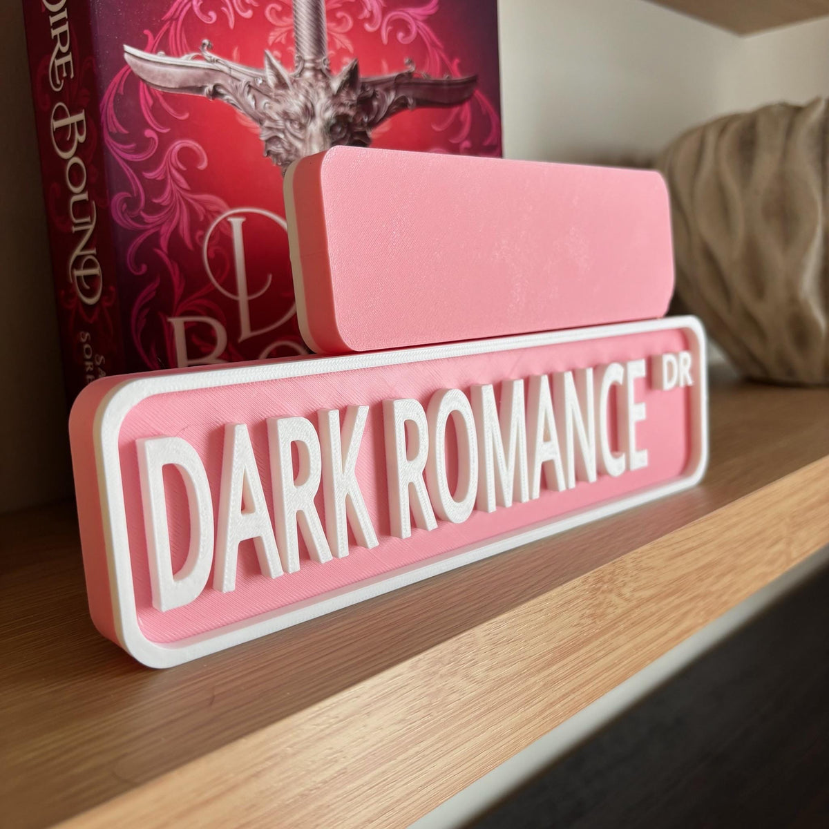 Back of the small pink sign behind the large DARK ROMANCE DR street sign