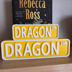 Front view of the small and large yellow and white DRAGON DR street signs