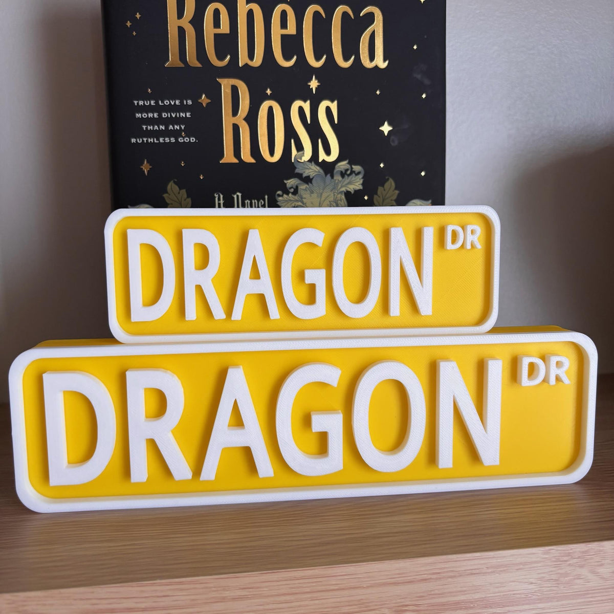 Front view of the small and large yellow and white DRAGON DR street signs