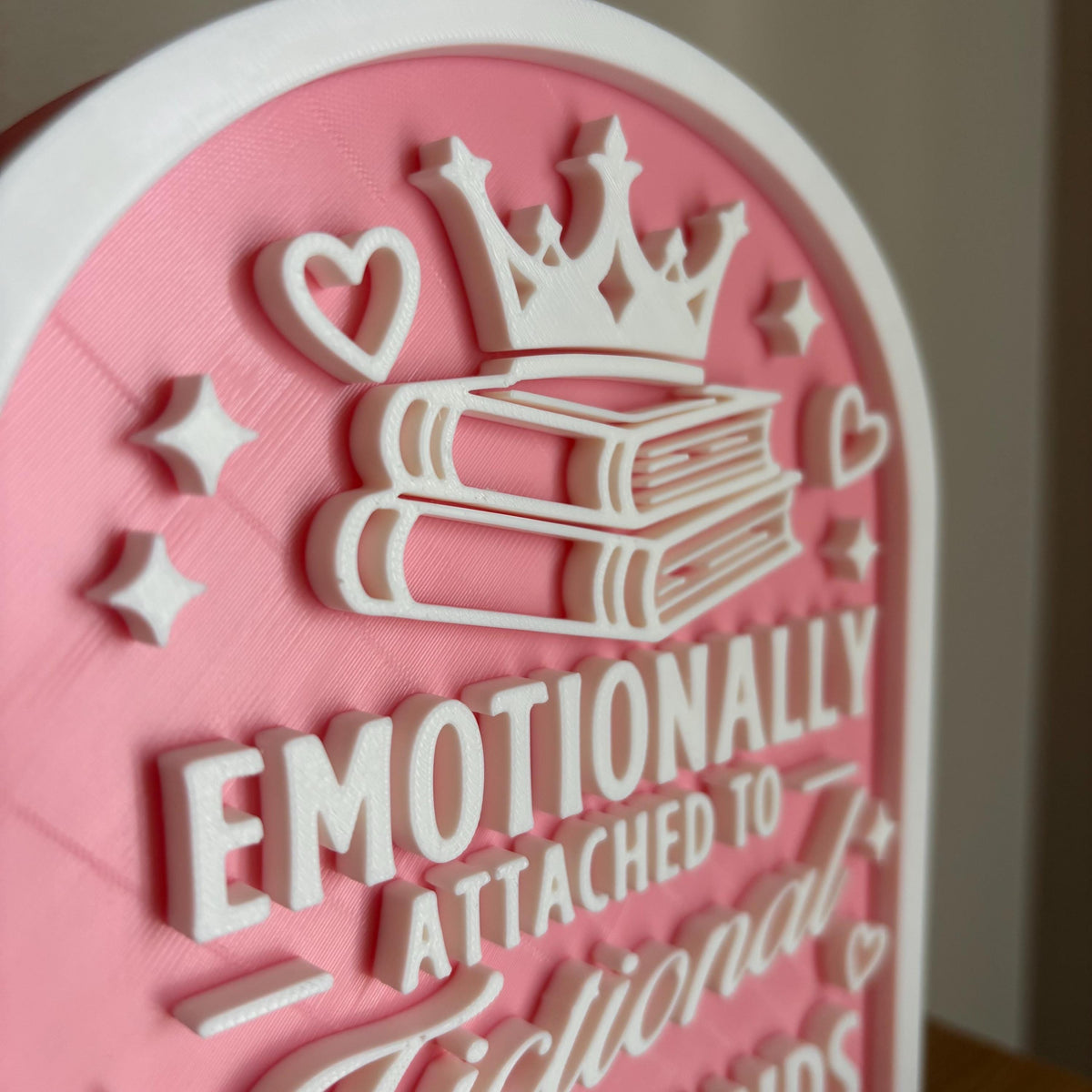 Angled close-up of the 3D printed crown and stacked books at the top of the Fictional Boyfriends sign