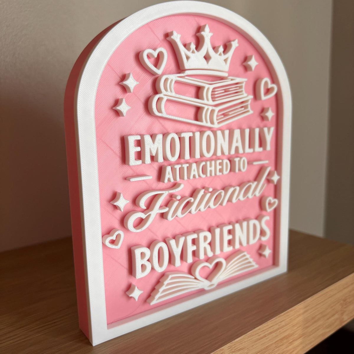 Three-quarter view of the Emotionally Attached to Fictional Boyfriends sign on a wooden bookshelf