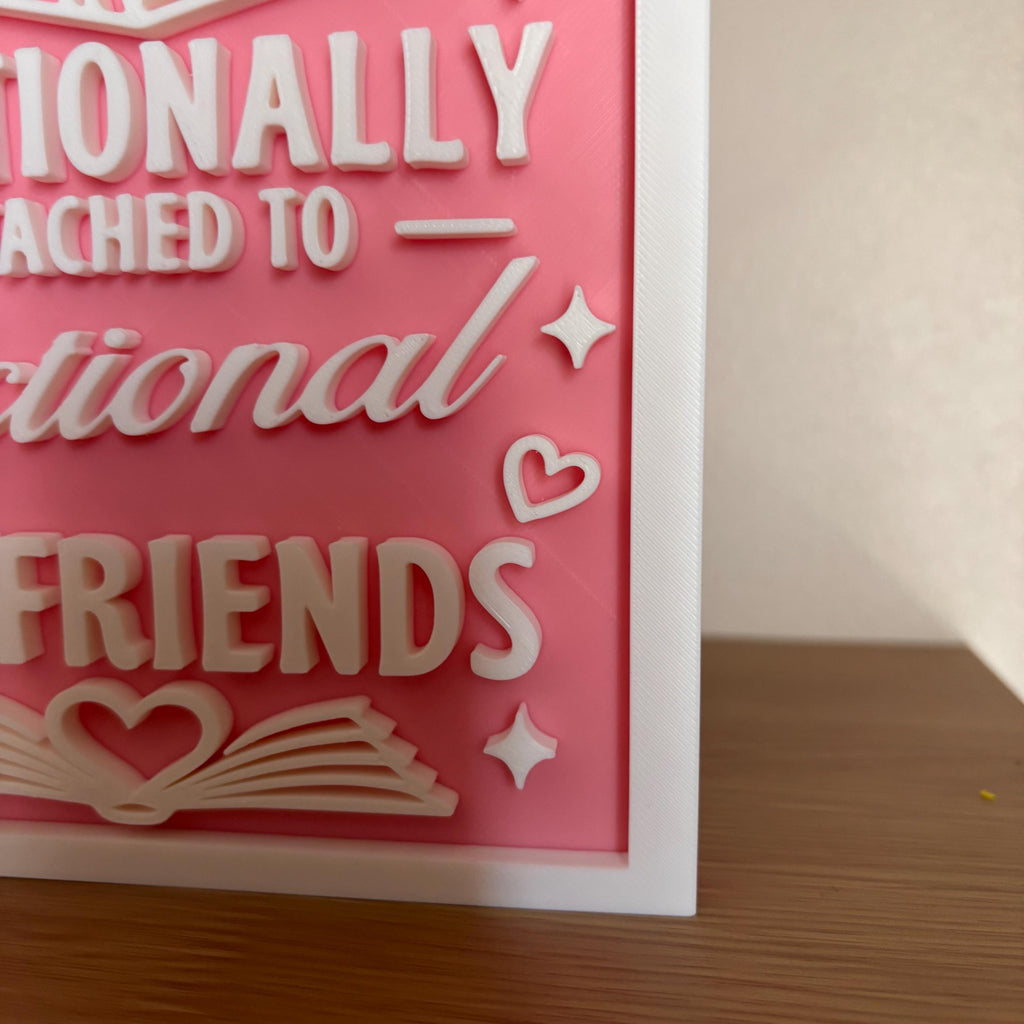 Corner detail of the white border, sparkle and heart accents on the pink Fictional Boyfriends bookshelf sign