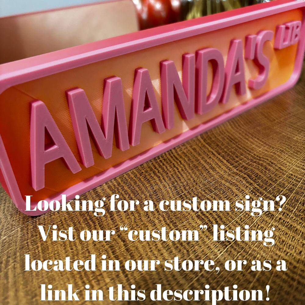 Custom pink and red AMANDA'S LIB street sign with text about ordering a custom sign
