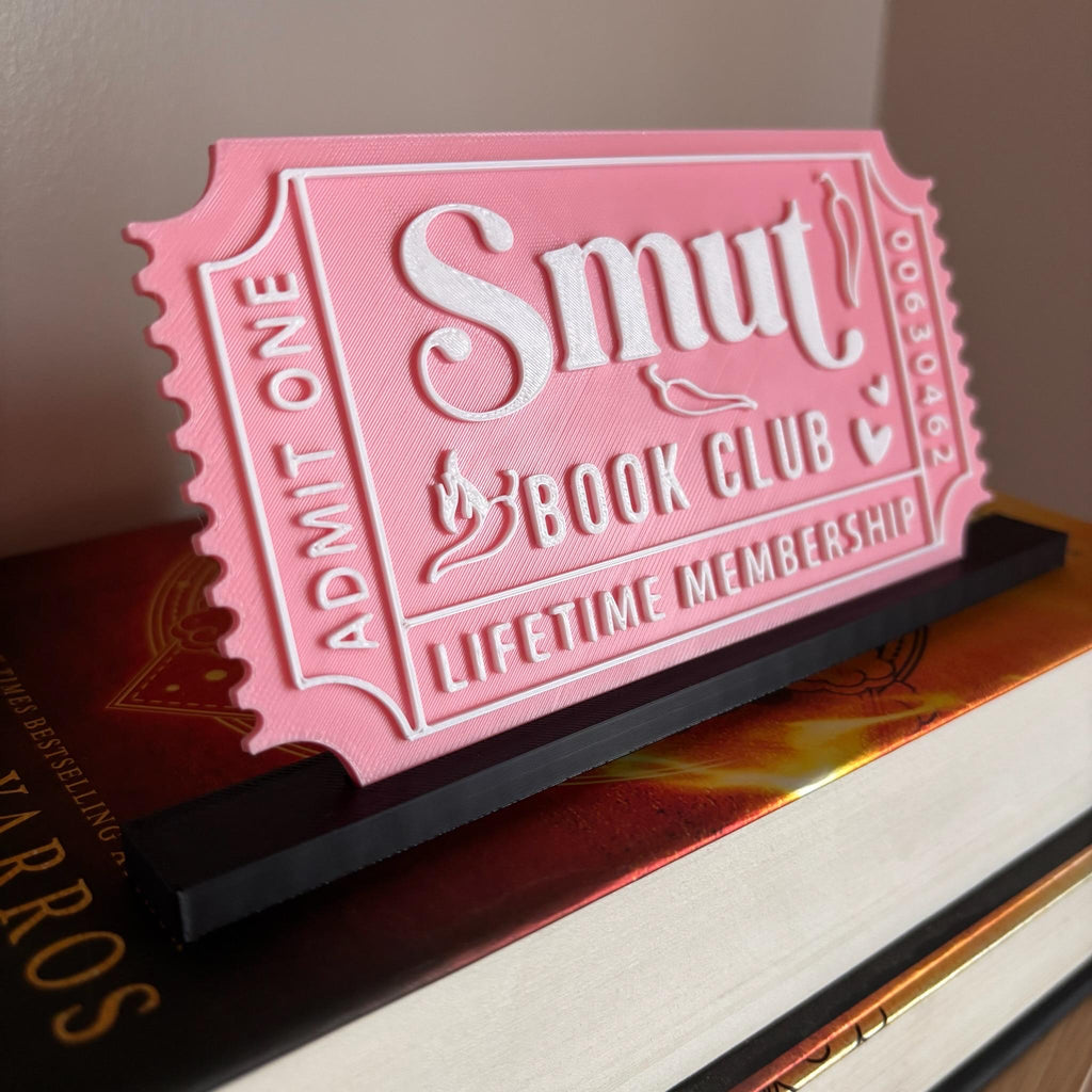 Pink Smut Book Club ticket with white lettering in a black stand